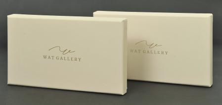 กล่อง WAT GALLERY เป็นกล่องฝาครอบ ใช้กระดาษแข็งจั่วปังปะด้วยกระดาษปอนด์ พิมพ์สีครีม ปั๊มฟอยล์ทองด้าน ตรงโลโก้ กล่องดูเรียบหรู สวยงาม กล่องด้านในติดซัพพอร์ต แบ่งพาร์ทิชั่น เป็นสองส่วน ส่วนแรกสำหรับใส่รูปภาพ และอีกส่วนหนึ่งสำหรับใส่แฟลชไดร์ฟ มีริบบิ้นสำหรับดึงรูปถ่าย