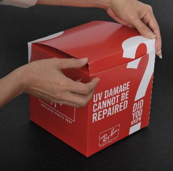 กล่องพิมพ์พื้นสีแดง ตัวหนังสือสีขาว ดีไซน์เครื่องหมายคำถามพาดจากตัวกล่องถึงฝากล่อง 